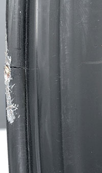 Black wheel with curb damage and bead flange crack